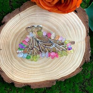 Detailed view of butterfly hair claw with natural crystals on rustic wood and moss