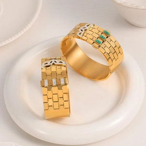 Gold-plated textured cuff bracelet featuring green stone and sparkling zircon accents