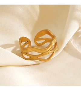 Macro shot of gold-plated wavy hollow ring on soft silk background, minimalist style