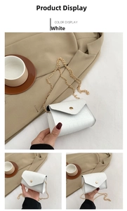 Detail of white crocodile pattern shoulder bag featuring gold chain and cylindrical buckle