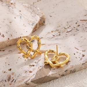 Detail of 18K gold stainless steel heart earrings with crystals on natural stone