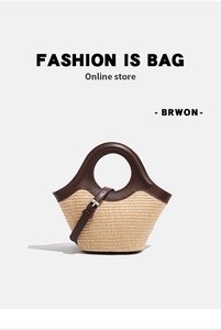 Detail of woven straw and brown leather handbag with round handles on white background