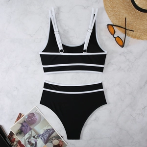 Detail of black and white bikini set with adjustable straps and high waist on marble