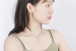 Close-up of silver cone-shaped necklace and earrings set worn by a fashion model