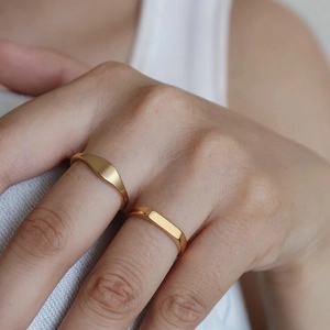 Close-up of geometric 18K gold plated stainless steel rings worn on fingers