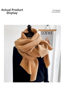 Detailed view of ginger yellow pleated scarf texture on a mannequin bust