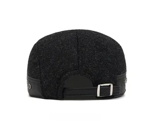 Detail view of wool winter cap with leather strap and silver metal buckle adjustment