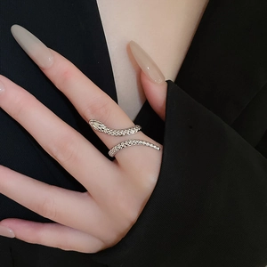 Close-up of silver snake-shaped open ring on a hand with black blazer background
