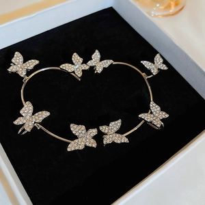 Detail of silver butterfly ear cuffs with sparkling crystals and curved wrap design