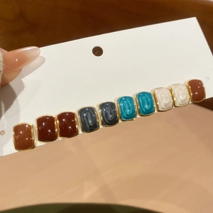 Detailed macro view of multi-color enamel square stud earrings set with gold metal edges