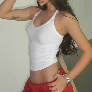 Close-up of white ribbed crop top featuring a deep V-neck and slim fit sporty design