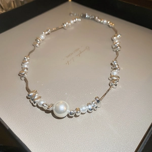 Detailed shot of pearl and irregular silver bead necklace with star-shaped light reflections