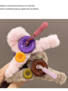 Close-up of plush hair claws with oversized colorful buttons and drawstring details