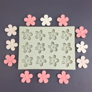 Macro detail of a 12-cavity silicone flower mold with pink and white floral samples