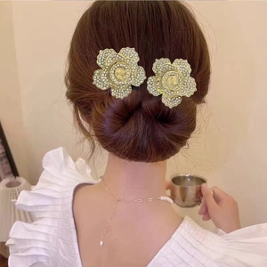 Gros plan d'une pince à cheveux rose dorée avec strass brillants sur un chignon