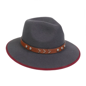 Detail of dark grey fedora hat with red brim trim and studded leather belt accessory