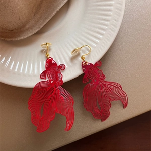 Detailed close-up of red koi fish earrings with intricate hollow carvings and gold hooks