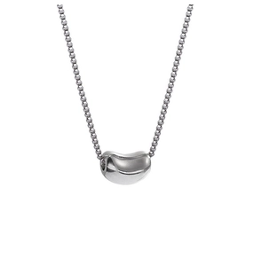 Detailed macro view of the silver bean pendant on a polished stainless steel chain