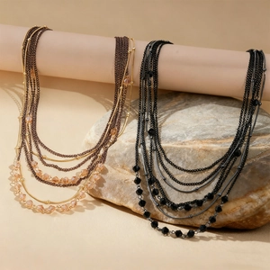 Close-up of multilayer layered necklaces with glass beads in gold and silver finishes