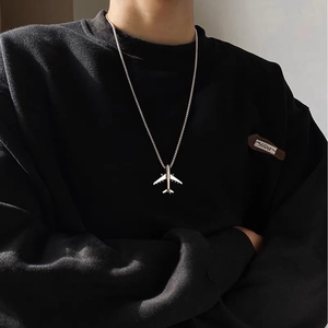 Men's minimalist silver airplane pendant necklace with metal box chain on black hoodie