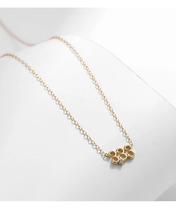 Détail du pendentif doré chiffre 333 avec gemme transparente sur fine chaîne maille
