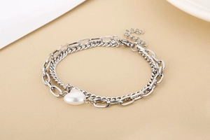 Detail of silver double-layer bracelet with heart pendant and paperclip chain links
