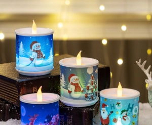 Close-up of LED Christmas candles with snowman and Santa prints on a festive table