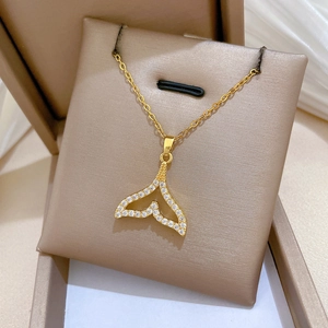 Detailed view of a gold-toned fish tail necklace featuring micro-set sparkling zircons