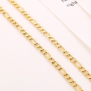 Detailopname van de gouden Figaro-ketting met gepolijste schakels op een witte kaart