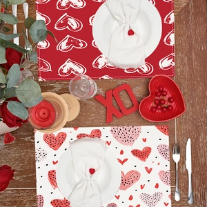 Red and white heart patterned Valentine placemats on dark wooden table with romantic decor