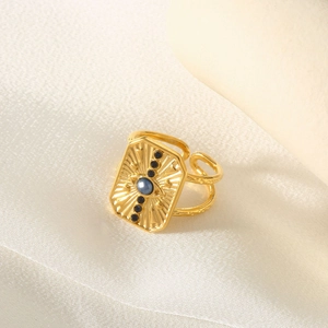 Detailed macro shot of a gold-tone open ring featuring a blue stone and French vintage design