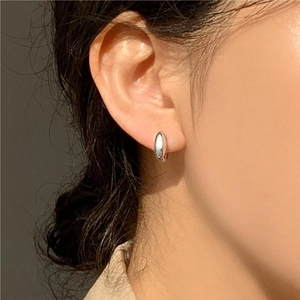 Minimalist 925 sterling silver hoop earrings shown on a model with elegant side lighting