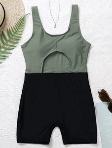 Detail of olive green and black colorblock monokini with abdominal cutout and flat shorts