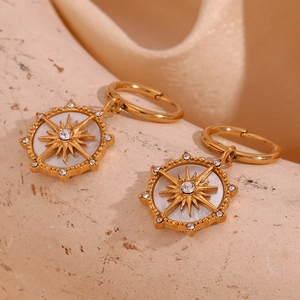 Gros plan sur les boucles d'oreilles étoile du nord en plaqué or 18 carats et nacre blanche