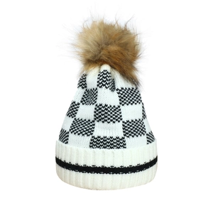 Detailed knit texture of checkerboard beanie with a fluffy faux fur pom-pom topper