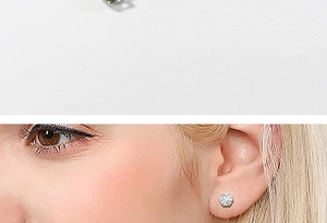 Detail view of silver round-cut cubic zirconia stud earrings and on-ear model styling