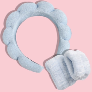 Soft microfiber spa headband and wristbands set in light blue on pink background