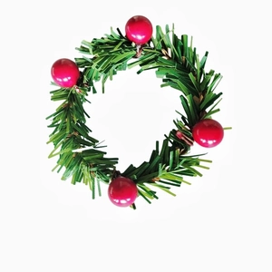 Vue détaillée du rond de serviette avec aiguilles de pin vertes et baies rouges de Noël