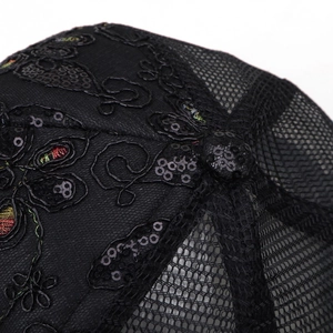 Macro shot of black baseball cap with sequined embroidery and breathable mesh texture