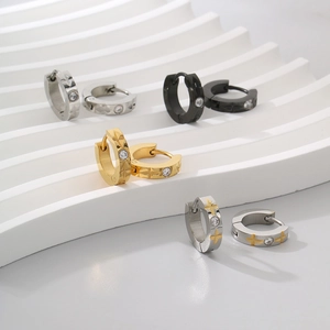 Detailed view of C-shaped titanium steel earrings with zircon inlay in four finishes