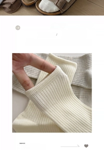 Detail of soft ribbed cotton socks in cream and light grey showing stretchable fabric
