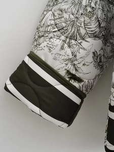 Détail du poignet d'une doudoune imprimée avec motifs botaniques noirs et bord-côte rayé
