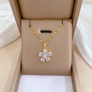 Close-up of gold flower pendant necklace with white zircons in a jewelry gift box