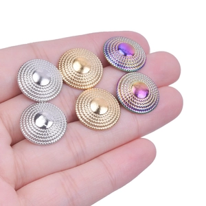 Detail of round stainless steel stud earrings with metallic grain texture and smooth center