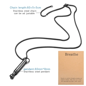 Close-up of mindfulness whistle pendant with adjustable chain and breathe card details