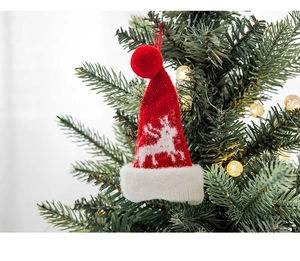 Nahaufnahme einer rot-weißen Strick-Weihnachtsmütze mit Rentier-Muster als Deko