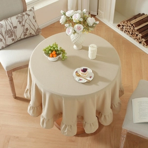 Detailed view of beige round washed cotton tablecloth with elegant ruffled edge hem
