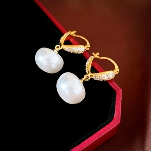 Élégantes boucles d'oreilles cœur en or avec perles blanches et diamants sur boîte en velours