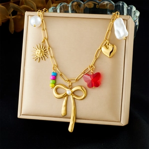 Fashionable gold stainless steel necklace with butterfly pendants and pearls on a stand