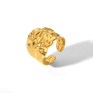 Detailed macro view of gold-toned wide hammered texture on a stainless steel open ring